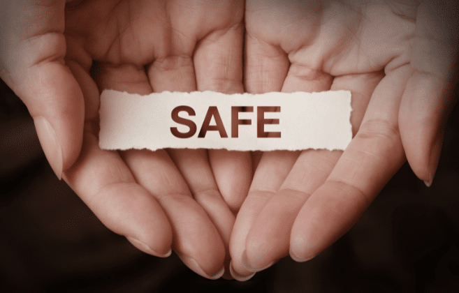 Hands holding a torn piece of paper with the word 'SAFE' on it, emphasizing the importance of safe cleaning practices.