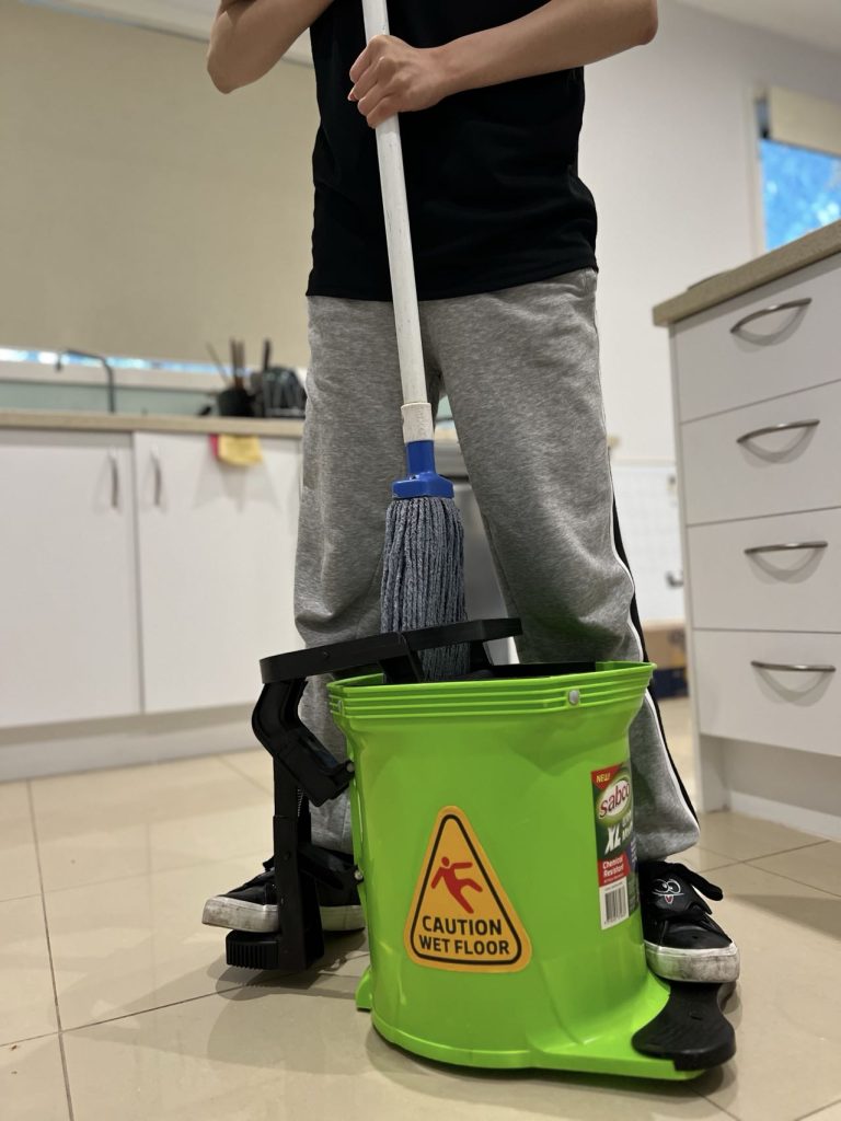 Cleaner using a mop and bucket during move-in cleaning to clean tiled floors.