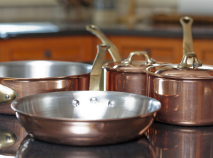 A set of clean and polished cast iron cookware placed on a kitchen countertop.