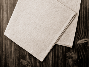 Close-up of neatly folded fabric napkins on a wooden surface.